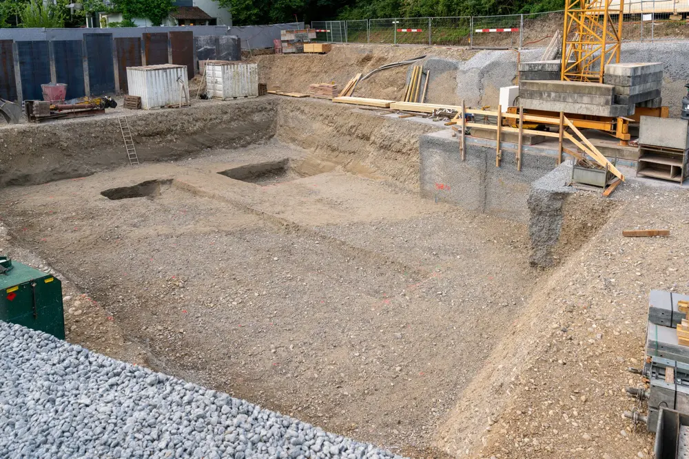 Excavation pit for building foundation in Helena, MT, with red construction markings for precise site preparation. Schaefer Excavating