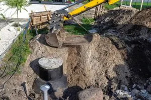 Excavator digging a septic system trench at a residential job site in Helena, Montana.