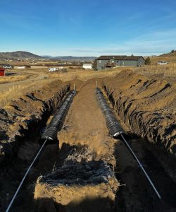 Septic installation Butte MT by Schaefer Excavating with excavator preparing septic tank and drain field area