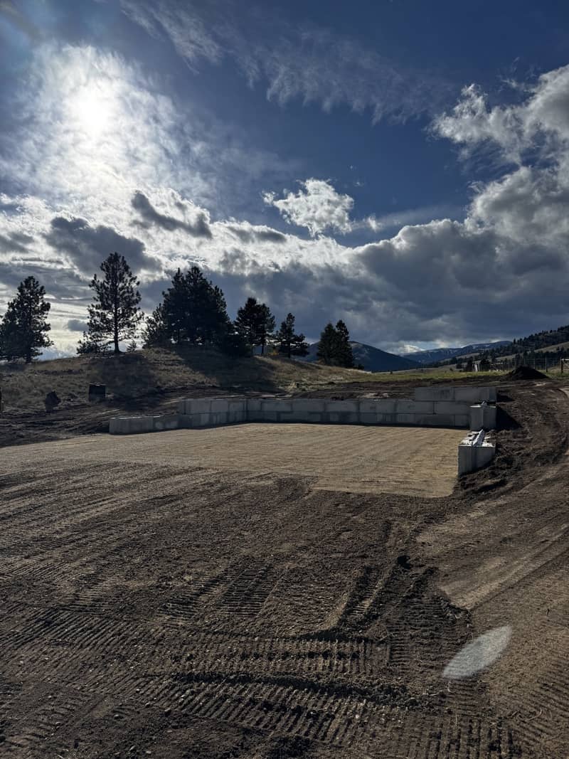 Finished excavation site in Bozeman, Montana with clean final grading and prepared foundation area